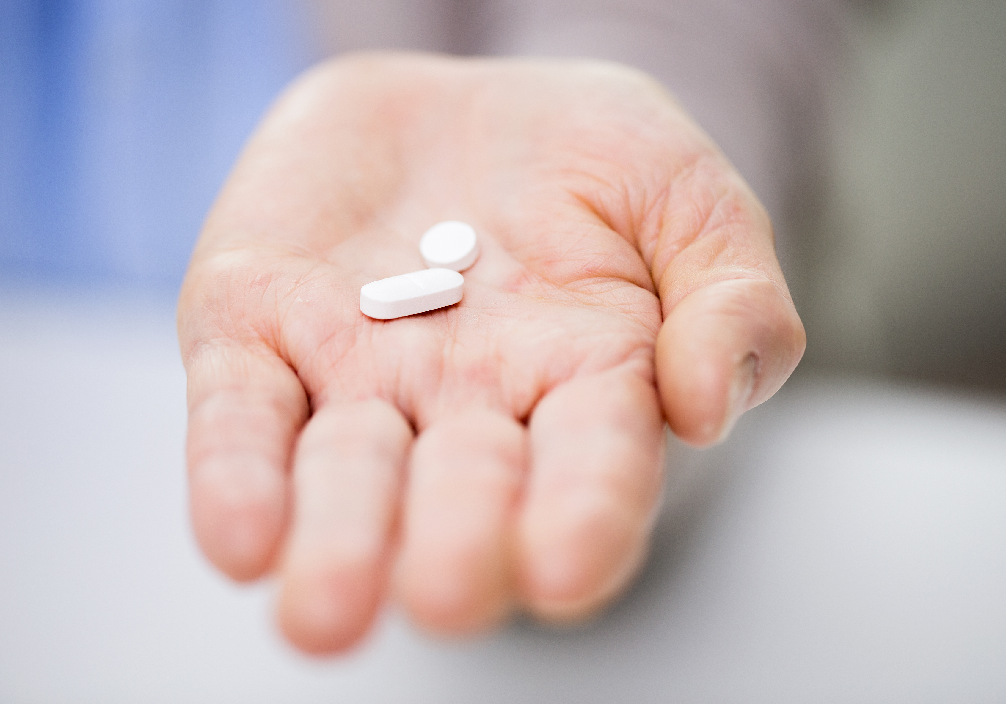 close up of senior woman hand with pills
